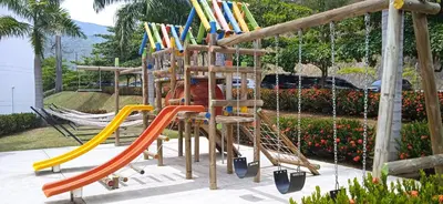 a playground with a slide and swings at Apartamento Citadela Di Sole Santa fe De Antioquia in Santa Fe de Antioquia