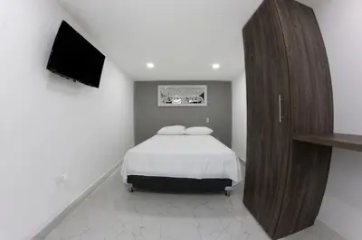 a bedroom with a bed and a flat screen tv at Nómada Hospedaje in San Rafael