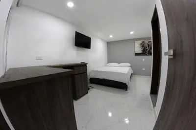 a bedroom with a bed and a desk in a room at Nómada Hospedaje in San Rafael