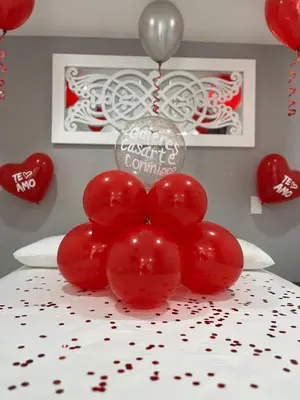 a bunch of red balloons on a table with hearts at Nómada Hospedaje in San Rafael