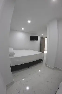 a bedroom with a bed and a tv on the wall at Nómada Hospedaje in San Rafael