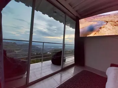 a room with a view of a beach on a tv screen at Apartamento Campestre y Turístico con Garaje y Mirador in Manizales
