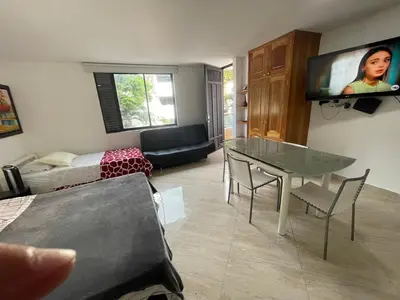 a living room with a table and a flat screen tv at En Laureles con ascensor , balcón y muy bien ubicado en laureles Medellín , EL BARRIO MAS COOL DEL MUNDO in Medellín