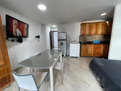 a living room with a table and a kitchen at En Laureles con ascensor , balcón y muy bien ubicado en laureles Medellín , EL BARRIO MAS COOL DEL MUNDO in Medellín