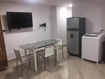 a dining room with a table and a refrigerator at En Laureles con ascensor , balcón y muy bien ubicado en laureles Medellín , EL BARRIO MAS COOL DEL MUNDO in Medellín