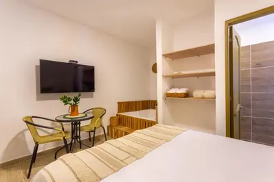a bedroom with a bed and a table and a tv at Entre Palmas Casa Hotel in Santa Fe de Antioquia