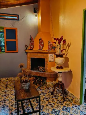 a living room with a fireplace and a table at Galilea in Santa Elena