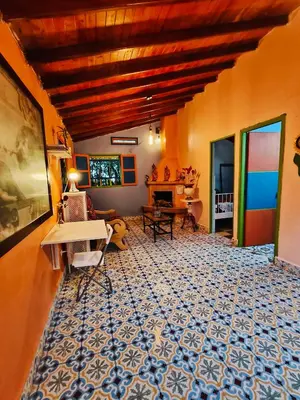 a living room with orange walls and a blue and white floor at Galilea in Santa Elena