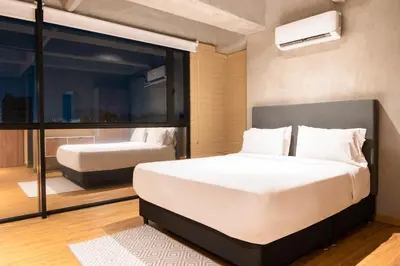 a bedroom with a large white bed and a window at Loft 43 in Medellín