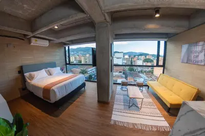 a bedroom with a bed and a couch and windows at Loft 43 in Medellín