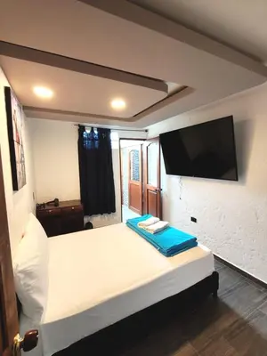 a bedroom with a large bed with a flat screen tv at Apartamento turístico jardín Antioquia in Jardin