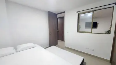 a white bedroom with a bed and a mirror at P.H Downtown - Tranvía in Medellín