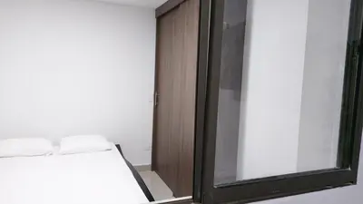 a bedroom with a bed and a glass door at P.H Downtown - Tranvía in Medellín