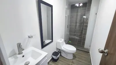 a bathroom with a sink and a toilet and a mirror at P.H Downtown - Tranvía in Medellín