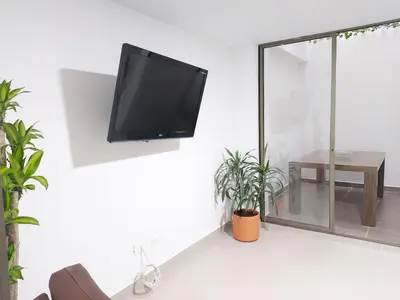 a flat screen tv hanging on a wall in a living room at P.H Downtown - Tranvía in Medellín