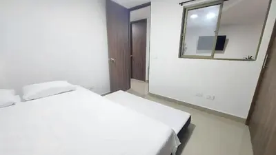 a bedroom with a white bed and a mirror at P.H Downtown - Tranvía in Medellín