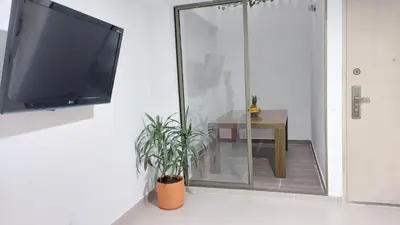 a flat screen tv hanging on a wall with a table at P.H Downtown - Tranvía in Medellín