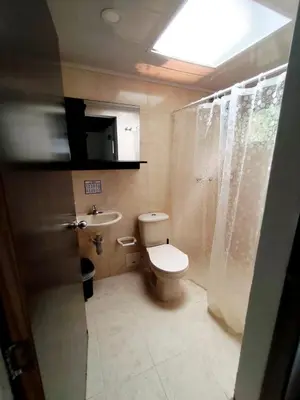 a bathroom with a toilet and a sink at Bosques de la Pradera in Manizales