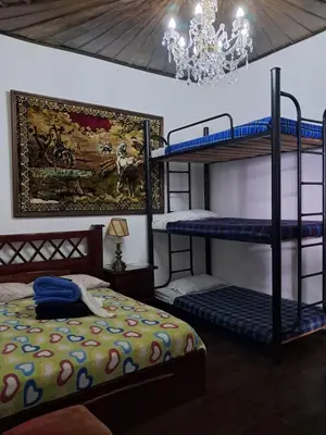 a bedroom with two bunk beds and a chandelier at Hostal Mirador Andino in Manizales