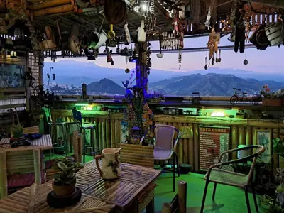 a room with a table and chairs and mountains in the background at Hostal Mirador Andino in Manizales