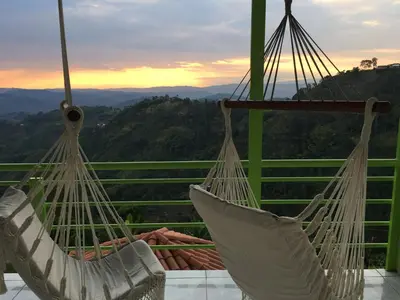 two hammocks on a balcony with a view of the mountains at Villa NiNa in Manizales