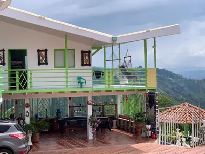 a house with a balcony with a table on it at Villa NiNa in Manizales