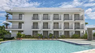 a building with a swimming pool in front of a building at Hotel Arbóreo Doradal in Doradal