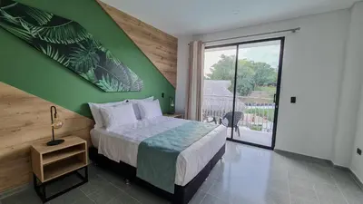 a bedroom with a bed with a green wall at Hotel Arbóreo Doradal in Doradal