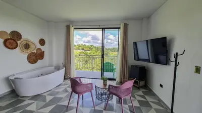 a bathroom with a tub and a table and chairs at Hotel Arbóreo Doradal in Doradal