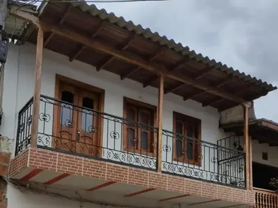 a balcony of a house with wooden doors at JARDIN SECRETO in Jardin