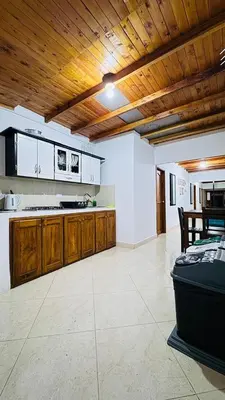 a large kitchen with wooden ceilings and a counter top at JARDIN SECRETO in Jardin