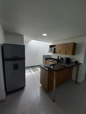 a kitchen with a refrigerator and a table in it at Apartamento El Trébol 101 in Jardin