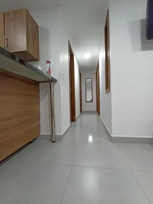 an empty hallway with wooden cabinets and a white tile floor at Apartamento El Trébol 101 in Jardin