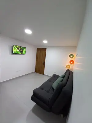 a living room with a black couch in a white room at Apartamento El Trébol 101 in Jardin