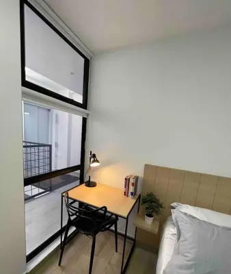 a bedroom with a table and a bed and a window at 80Cooliving Medellín in Medellín