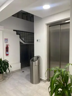 a lobby with a metal trash can in a building at 80Cooliving Medellín in Medellín