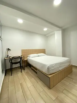 a bedroom with a large bed and a table at 80Cooliving Medellín in Medellín