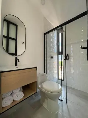 a bathroom with a toilet and a sink and a mirror at 80Cooliving Medellín in Medellín