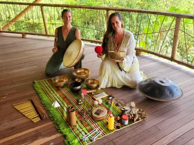 two women sitting on a deck with food on a table at Ecofinca Fuente Alegre in Cocorná