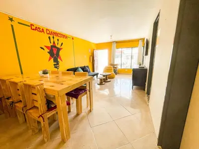a dining room with a wooden table and yellow walls at Casa Clandestina Guest House in Medellín