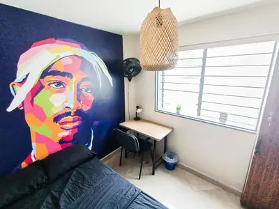 a bedroom with a painting of a woman on the wall at Casa Clandestina Guest House in Medellín