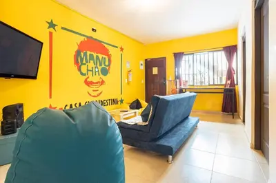 a living room with a blue chair and a tv at Casa Clandestina Guest House in Medellín