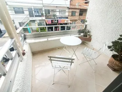 a balcony with a table and chairs on a building at Casa Clandestina Guest House in Medellín