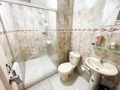 a bathroom with a shower and a toilet and a sink at Casa Clandestina Guest House in Medellín