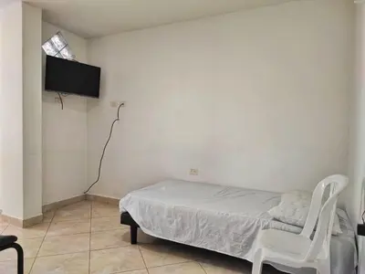 a bedroom with a bed and a tv on a wall at Apartamentos con estacionamiento cerca al parque in Támesis