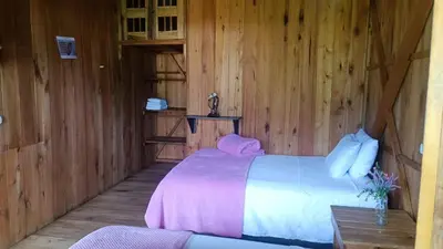 a bedroom with a bed in a wooden room at Cabañas Villa Juliana in Jardin
