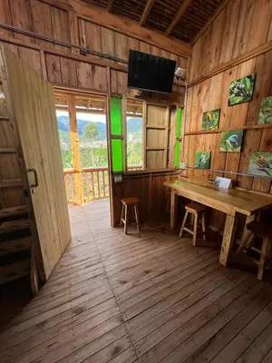 a wooden room with a wooden table and a television at Cabañas Villa Juliana in Jardin