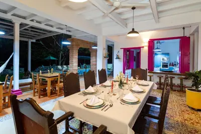 a dining room with a long table and chairs at Casa Etnika in Jericó