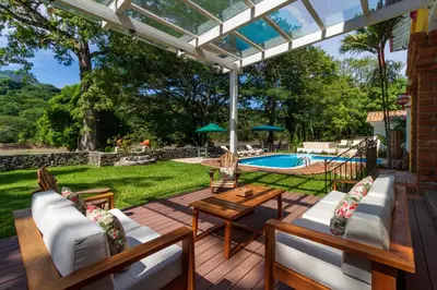 a patio with chairs and a table and a pool at Casa Etnika in Jericó