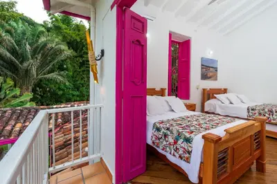 a bedroom with two beds on a balcony at Casa Etnika in Jericó